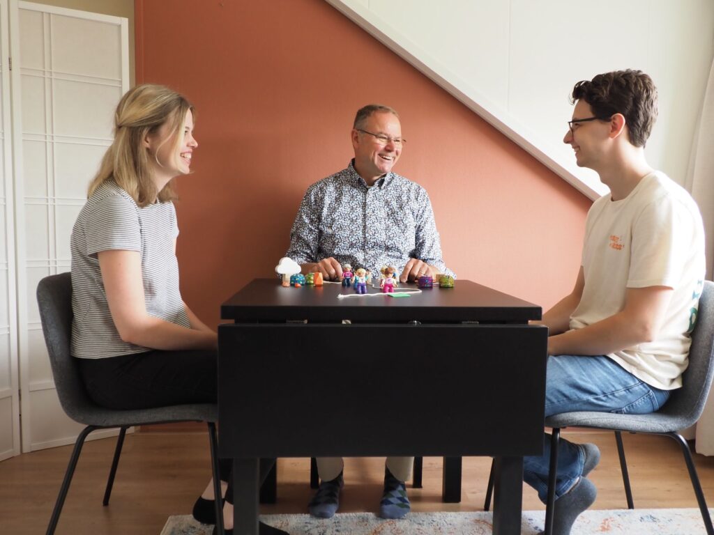 Ferry Boers in gesprek aan de systeemtafel met twee cliënten